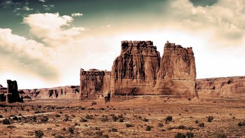 Image brown rock formation under white clouds during daytime