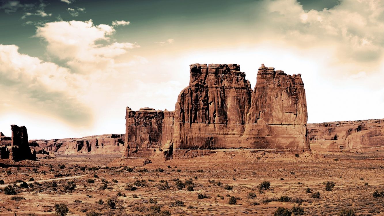 brown rock formation under white clouds during daytime