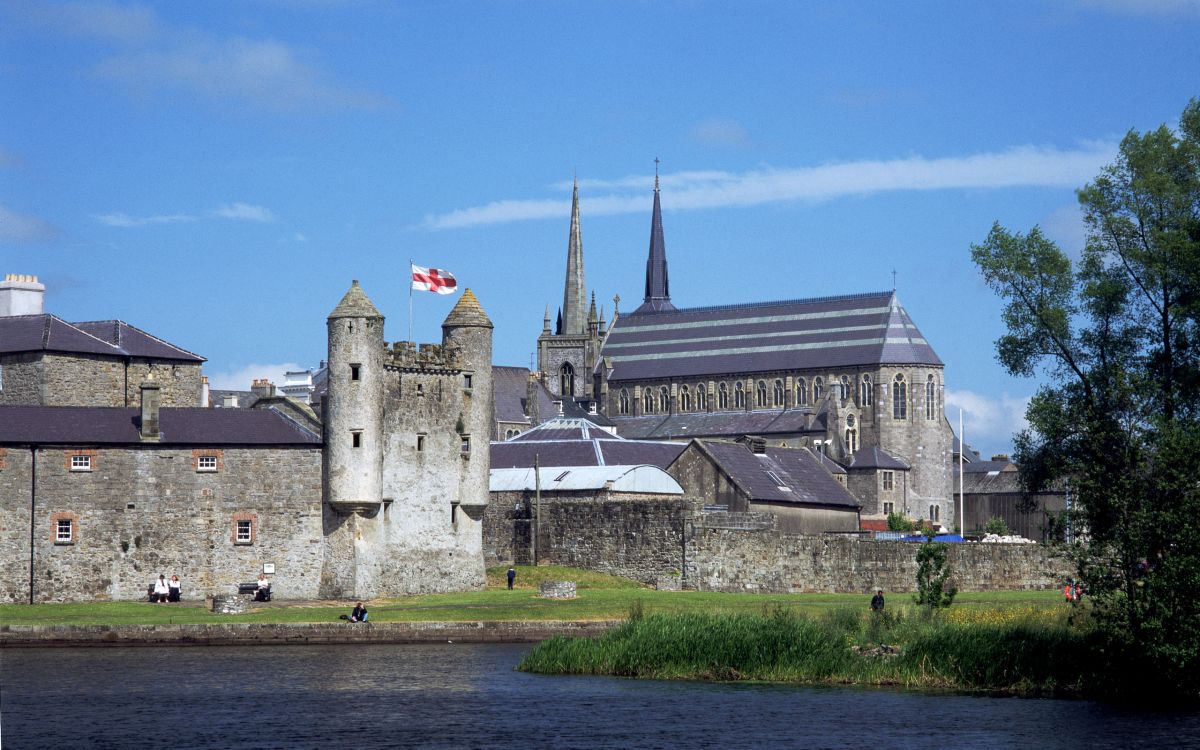 gray concrete building near river under blue sky during daytime