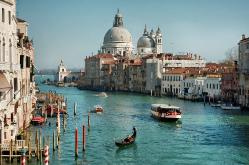 Image people riding on boat on river near city buildings during daytime