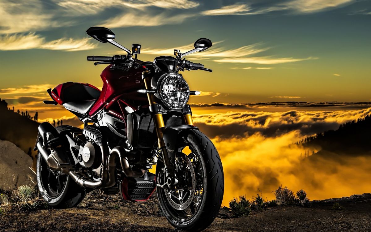 red and black motorcycle on brown field during sunset